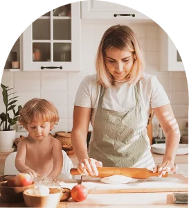 A woman and child kneading dough in a kitchen, bonding over baking