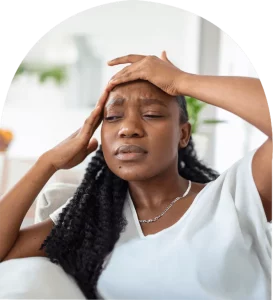 Stressed woman holding her head in pain, showing signs of a headache