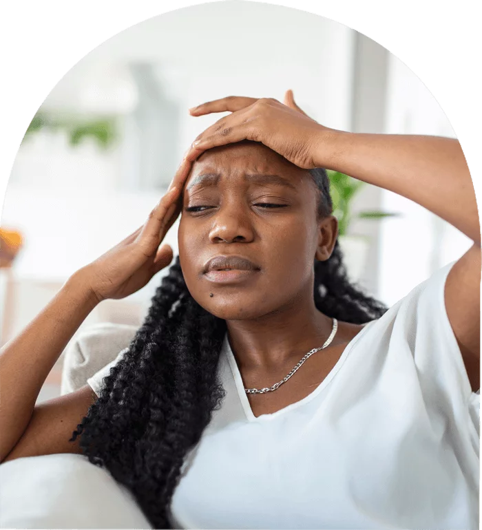 Stressed woman holding her head in pain, showing signs of a headache